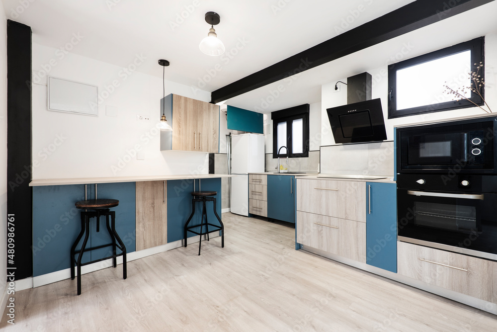 loft kitchen with color scheme indigo blue black and light wood paneling