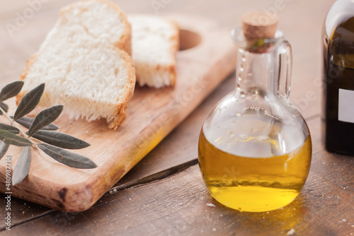  Olive oil and slices of bread on wooden background. Mediterranean diet concept