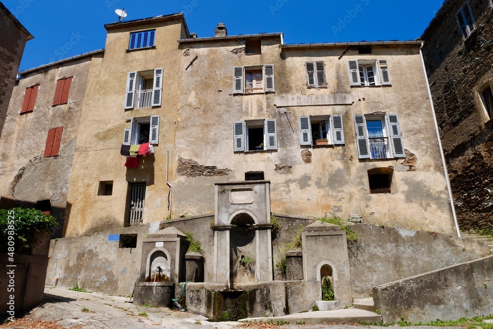 Traditional stone houses and fountain in Stazzona, a dreamy mountain village nestled in the mountains of Castagniccia. Corsica, France.