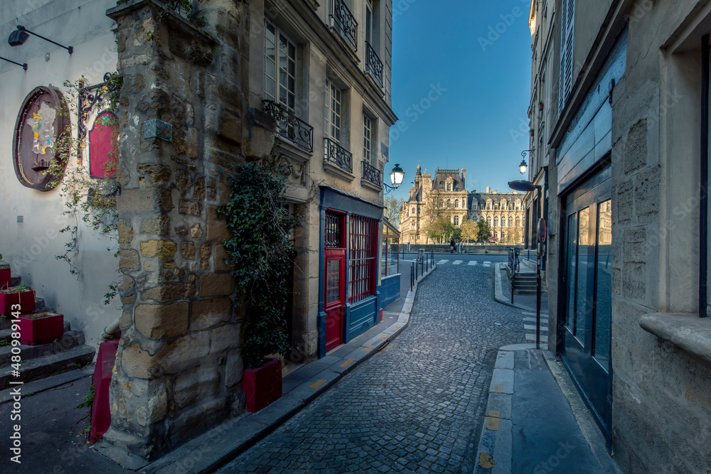 Paris, France - April 3, 2021: Small cosy street with City Hall in background in Paris