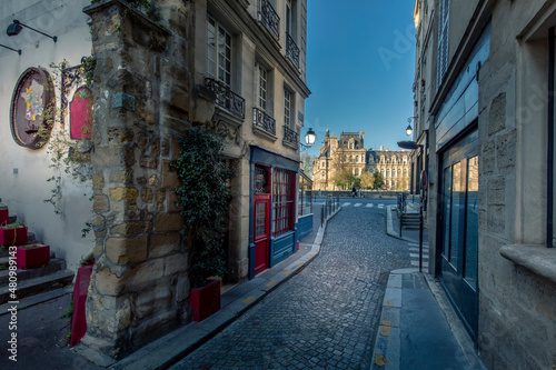 Paris, France - April 3, 2021: Small cosy street with City Hall in background in Paris