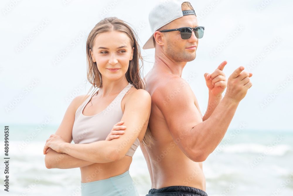 Sport man and woman exercise on beach at daytime