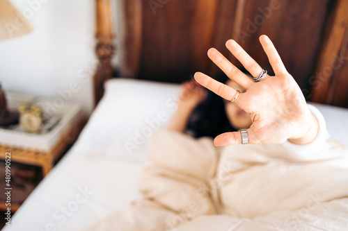 Unrecognizable young woman does not want to get out of bed in the morning