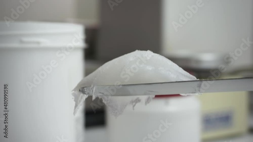 Appearance of a portion of stringy Vaseline caught with a spatula in the pharmacy laboratory. Macro view 