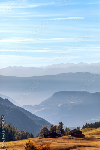 Autumn in Seiser Alm. Morning fog covers the mountains of Val Gardena (Vertical photo)