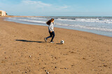 Little girl on the beach plays with a soccer ball. Sports, recreation, vacations. Family outdoor sports games