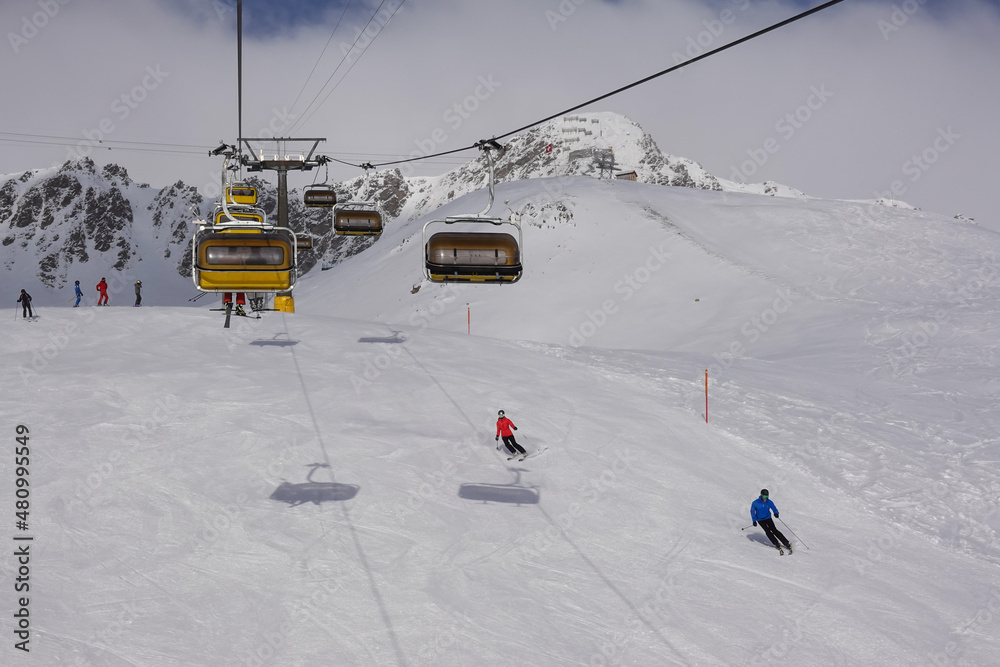 Skiers and chair lift in the Saint Moritz ski resort in the alps in Canton Graubunden in Switzerland