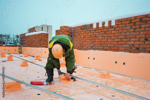 a builder on the roof. installation of roof insulation