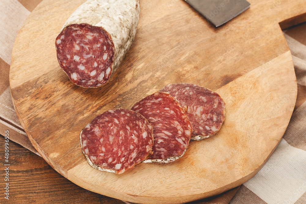 Iberian dry cured pork sausage sliced on wooden background Iberian dry cured pork sausage sliced on wooden background