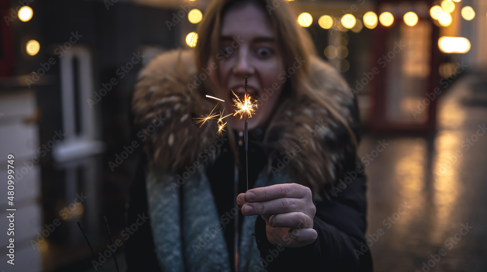 Burning sparklers in the hands of a young woman in the dark. Burning sparklers in the hands of a young woman in the dark.