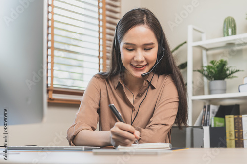 Video call, meeting conference via camera, happy pretty asian young woman, girl sitting, wear wireless headphone study online, using laptop computer, freelancer working.Technology, social distance.