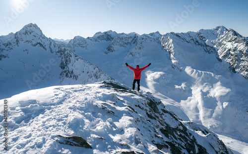 Traveler stands back and hands up looking scenery the mountain. Feeling freedom concept winter day, popular adrenaline activity,