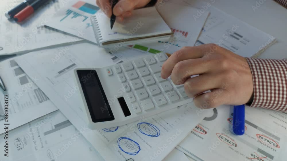 Analyst calculates data on the company's financial profits on a calculator top view Analyst calculates data on the company's financial profits on a calculator top view