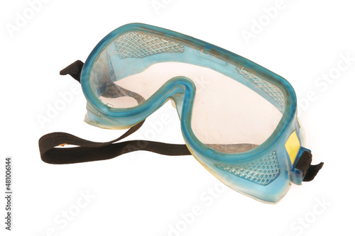 Dirty safety goggles on a white background, as used on construction sites.