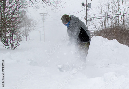 man throwing a shovel full of snow photo