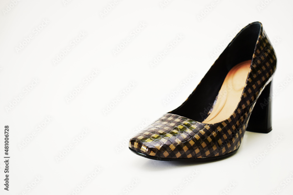 Fototapeta premium Zapato de tacón alto café y negro. Zapato para mujer sobre un fondo blanco, espacio para texto al lado izquierdo.