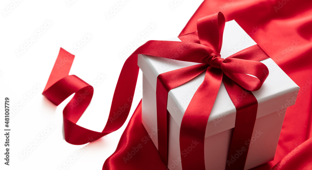 Gift box with red ribbon curly decoration on satin, empty space. Valentine day gift, Christmas present Gift box with red ribbon curly decoration on satin, empty space. Valentine day gift, Christmas present