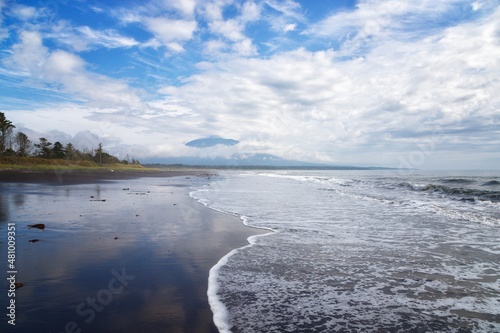 The coast of the Pacific Ocean and Tyatya volcano, covered with clouds. Kunashir. Southern Kuriles photo