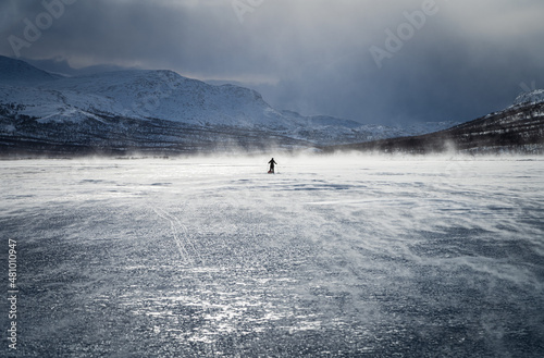Cross country skier with sled (pulka) on a frozen river in in national park Sarek. Lapland, Sweden.