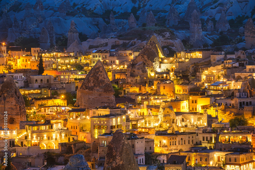 Goreme, Cappadocia, Turkey. View of the evening city from the mountain. Bright evening city. Landscape in the summertime. UNESCO heritage. Vacation and tourism.
