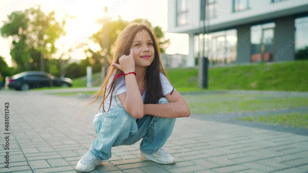 Portrait of positive girl with long hair looking at camera an sunset Portrait of positive girl with long hair looking at camera an sunset