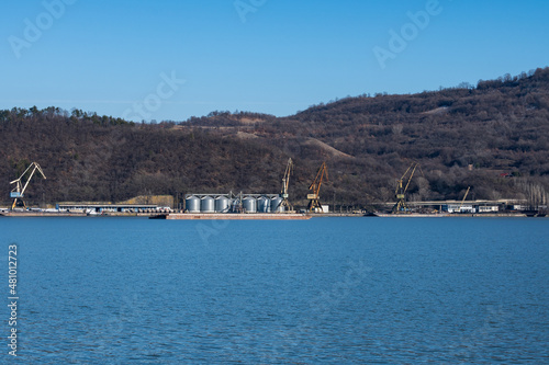 Grain silos and cranes for loading on ships. Port on the bank of the Danube.  photo