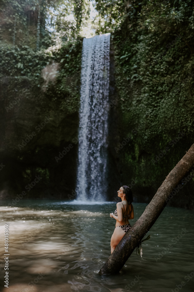 A young female traveller exploring waterfall in Bali. Nature, green lush tropical landscapes, water, woman A young female traveller exploring waterfall in Bali. Nature, green lush tropical landscapes, water, woman