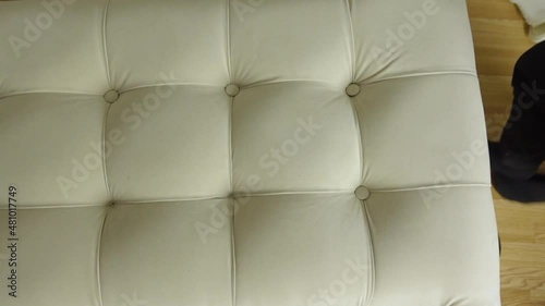 Man's hands upholster bed with new fabric and insert buttons with sewing needle photo