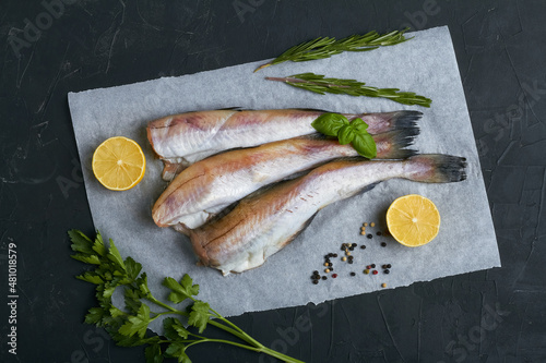 raw pollock fish lemon parsley rosemary flat lay top view black background copy space