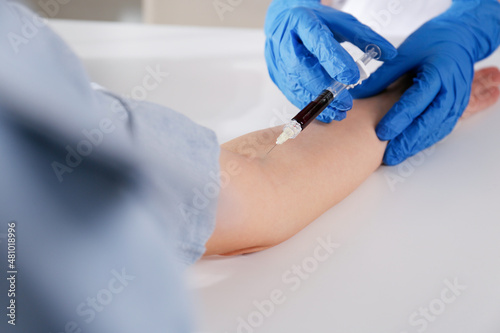 Nurse drawing blood sample from patient in clinic  closeup