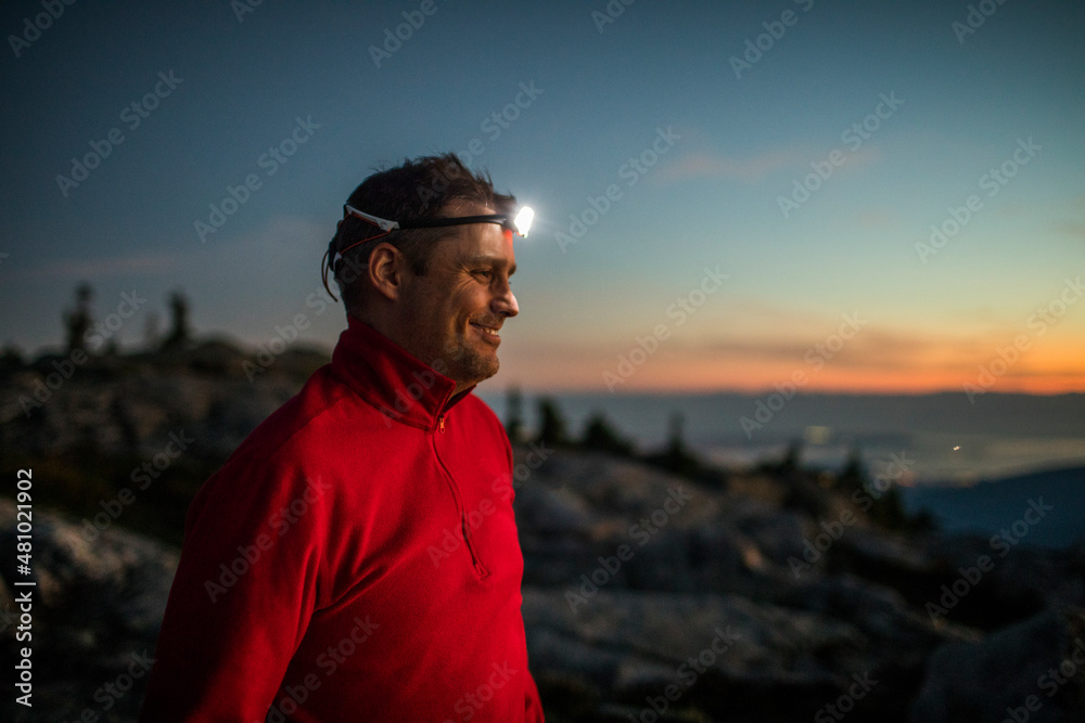 Portrait of active smiling man wearing headlamp while trail running. Portrait of active smiling man wearing headlamp while trail running.