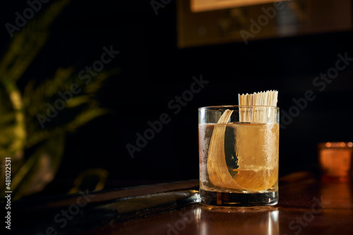 A mostly transparent craft cocktail with a cornhusk garnish.