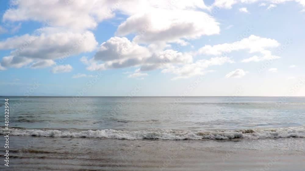 Relaxed scene with calm sea, blue sky, few clouds and a beautiful beach Relaxed scene with calm sea, blue sky, few clouds and a beautiful beach