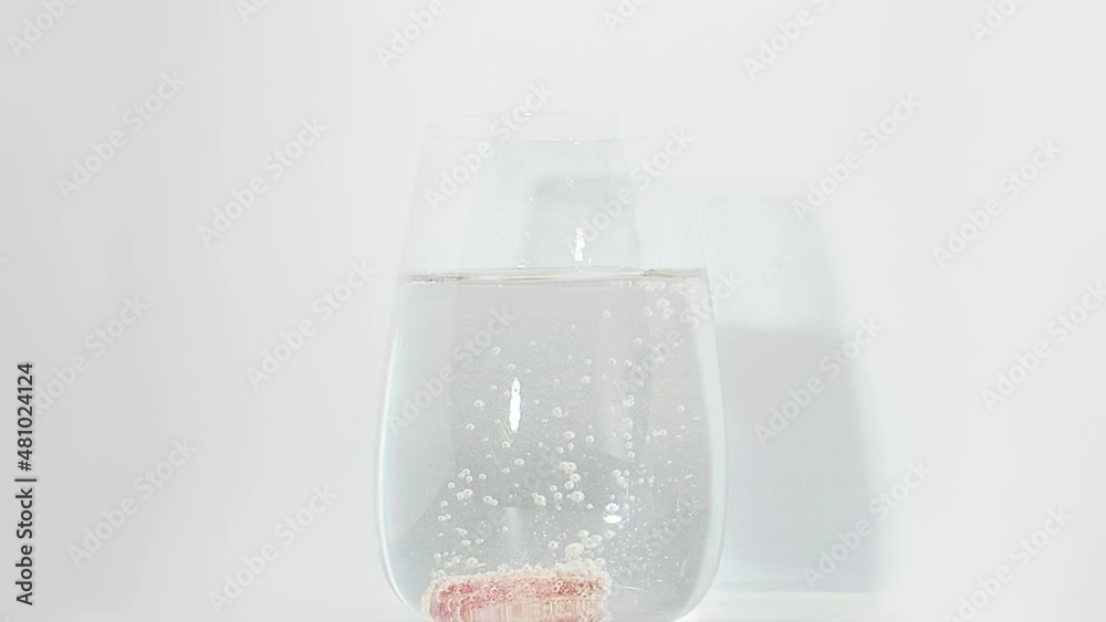 Vitamin pill falling down in glass with water. effervescent tablet . closeup on white background Vitamin pill falling down in glass with water. effervescent tablet . closeup on white background