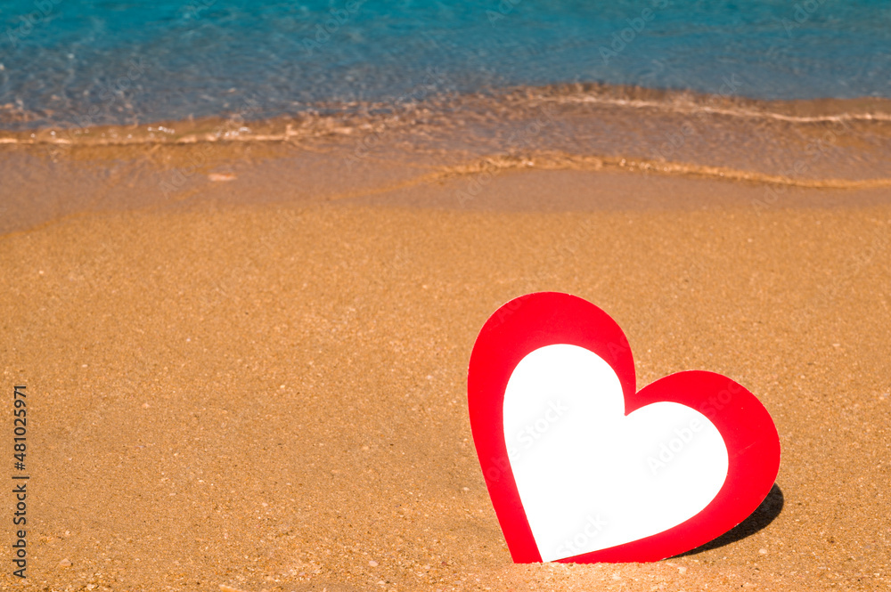 Paper card heart shaped in the sand on the beach.St valentine's in tropics. Banner with place for text