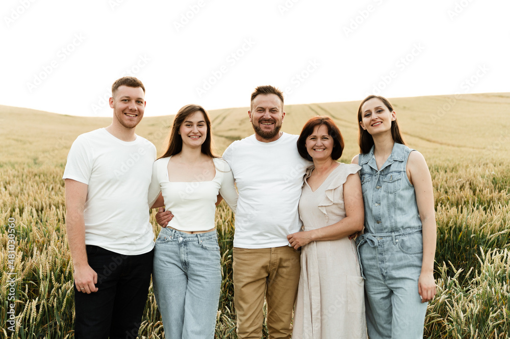 portrait of a happy family. father with mother and adult children in the field. large family of middle age. family at sunset on a sunny summer day. portrait of a happy family. father with mother and adult children in the field. large family of middle age. family at sunset on a sunny summer day.