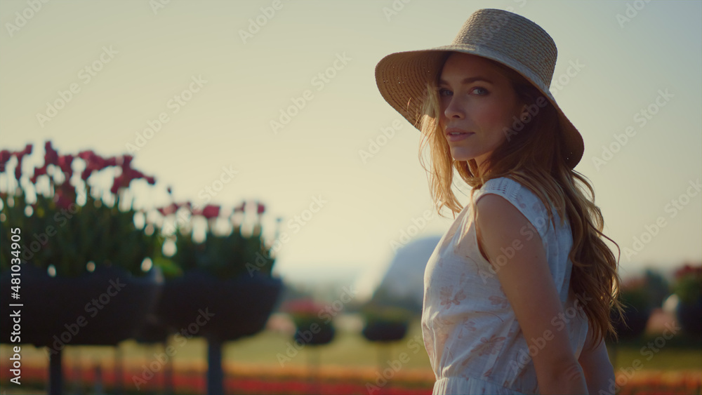 Fototapeta premium Sensual woman looking at camera outdoors. Beautiful girl turning face to sun. 