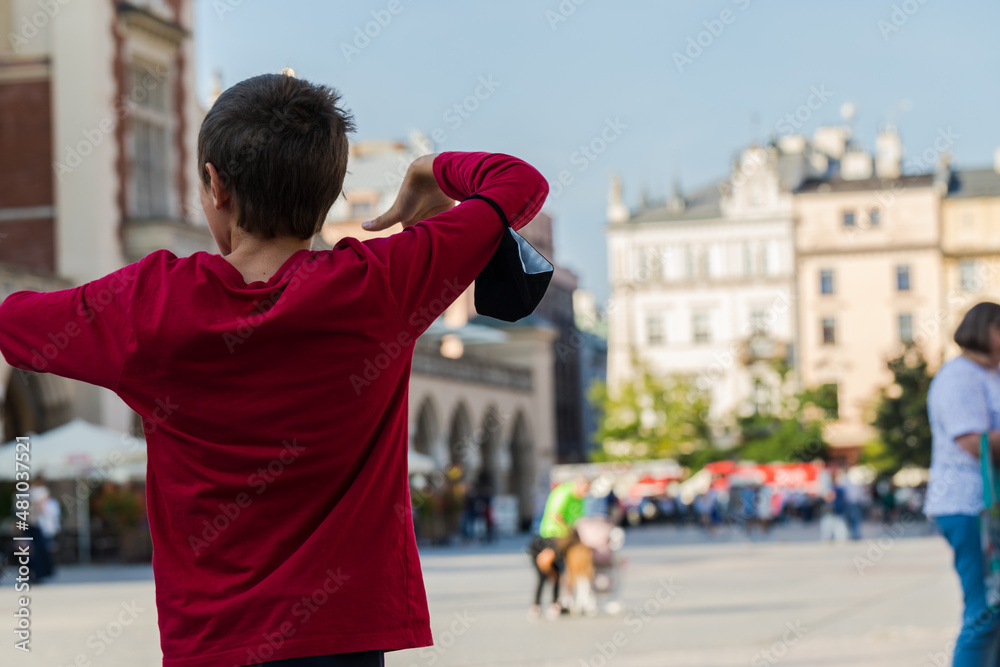 A young boy in a red sweatshirt with his back turned dancing. A young boy in a red sweatshirt with his back turned dancing.