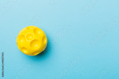 Yellow spiky ball toy for pet on color background
