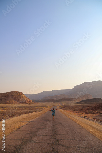girl walking in desert road