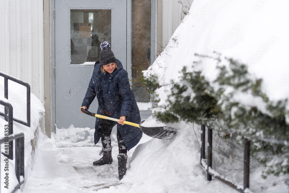 Fototapeta premium Woman Shovelling Snow