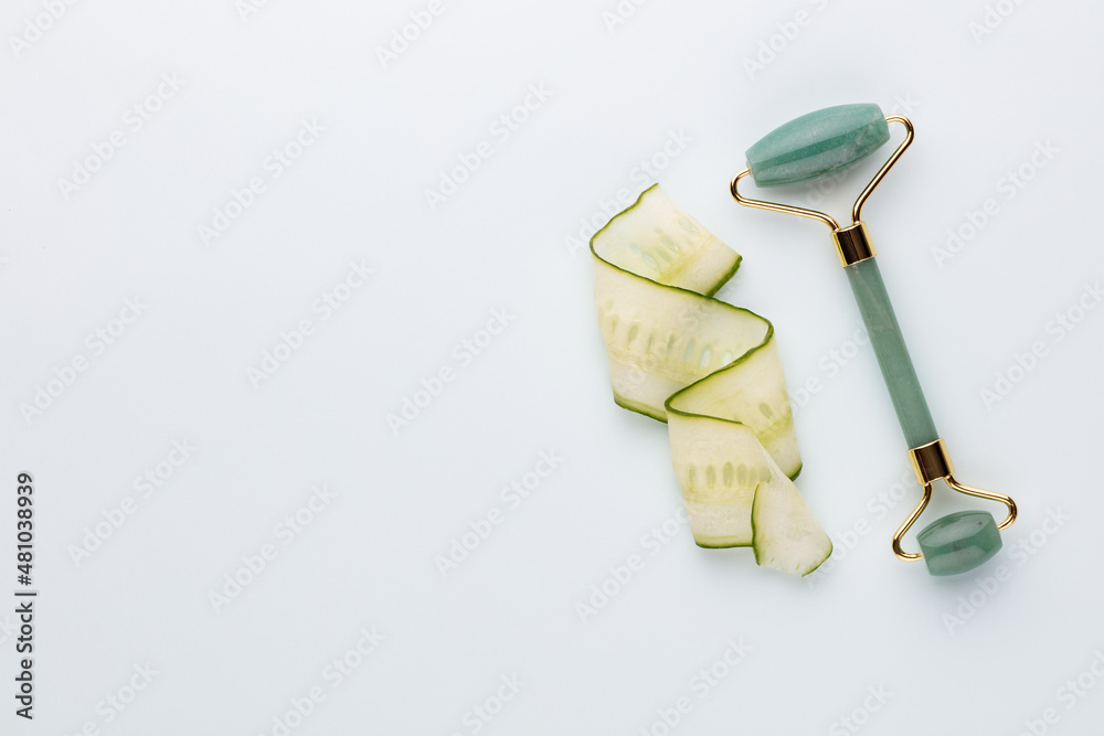 Quartz face roller on blue background. Massage tool for facial skin care, SPA beauty treatment concept. Flat lay, top view Quartz face roller on blue background. Massage tool for facial skin care, SPA beauty treatment concept. Flat lay, top view