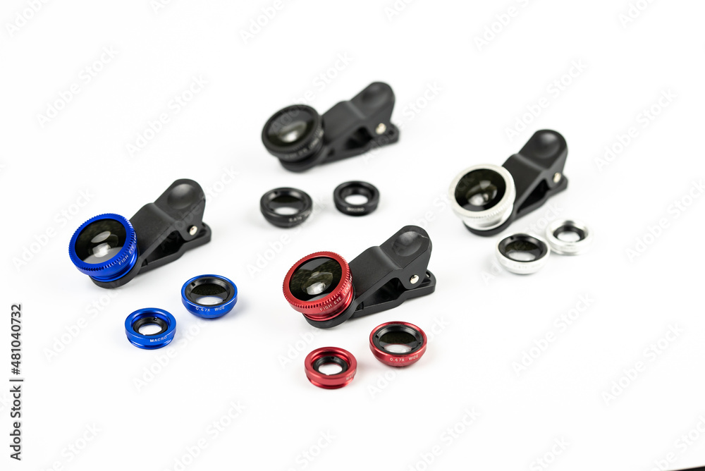 Phone photo lens with clips on white background. Extra macro camera for smartphone. Set of lenses wide angle, fish eye and macro Phone photo lens with clips on white background. Extra macro camera for smartphone. Set of lenses wide angle, fish eye and macro