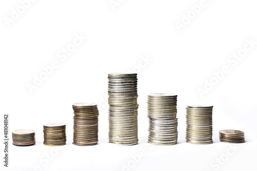 stacks of coins show growth in income and economy and then decline on a white background