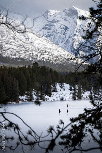 Hockey Players and ice skaters skating on a frozen mountain lake in Banff National Park.