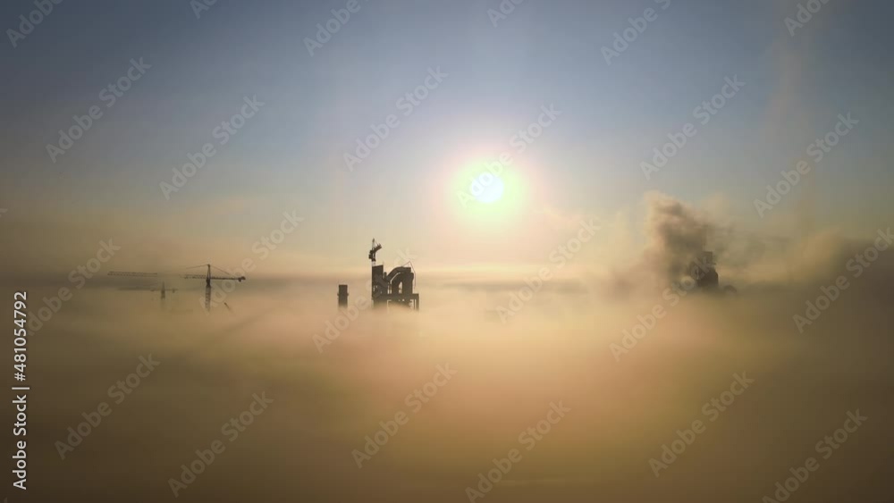 Aerial view of cement factory with high concrete plant structure and tower crane at industrial manufacturing site on foggy evening. Production and global industry concept Aerial view of cement factory with high concrete plant structure and tower crane at industrial manufacturing site on foggy evening. Production and global industry concept