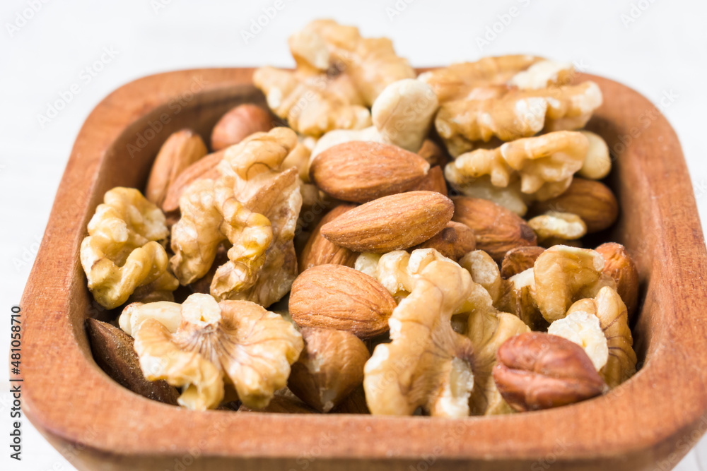 Assortment of nuts close up on wooden bowl. Healthy diet concept Assortment of nuts close up on wooden bowl. Healthy diet concept