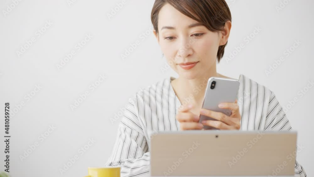 ノートパソコンとスマートフォンを使う女性 ノートパソコンとスマートフォンを使う女性