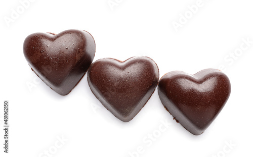 Tasty heart-shaped candies on white background