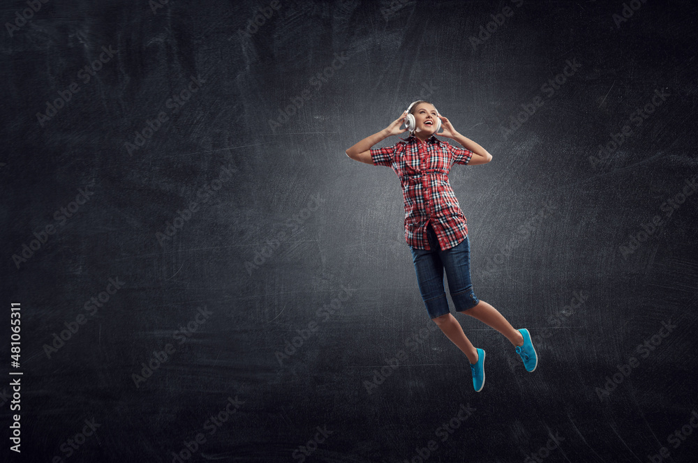 Woman wearing headphones jumping . Mixed media Woman wearing headphones jumping . Mixed media